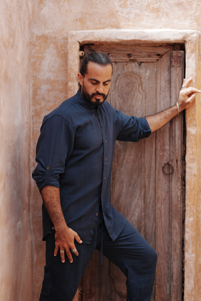 Man in a blue linen button up shirt and matching linen pants