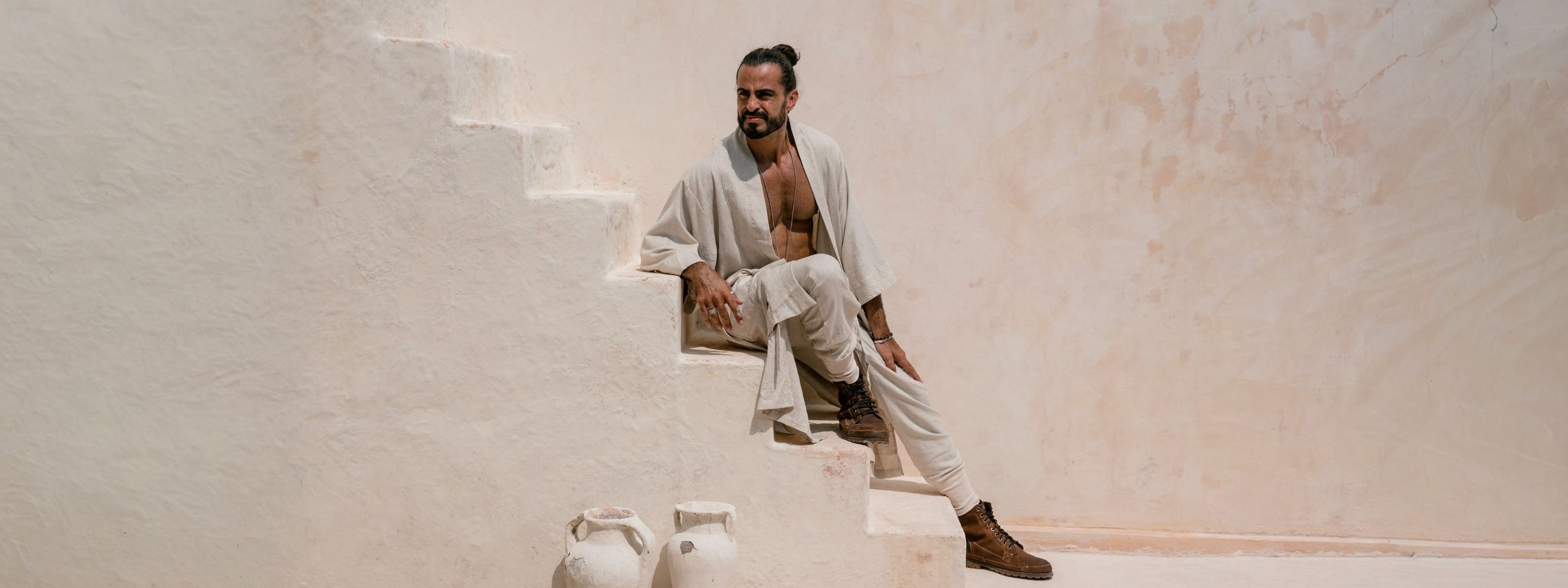 Man sitting on a staircase wearing VALO Bushi Cream Outfit